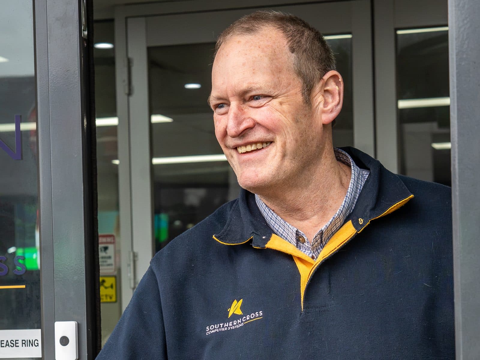 A smiling SCCS team member welcoming a visitor at the Port Melbourne front door